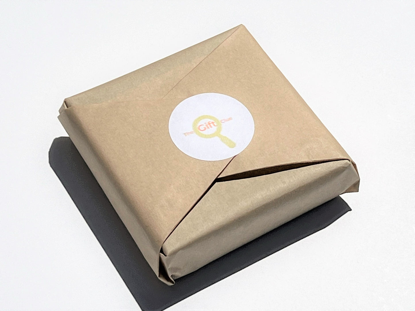 Gift-wrapped box in kraft paper with TheGiftClue sticker on top.background