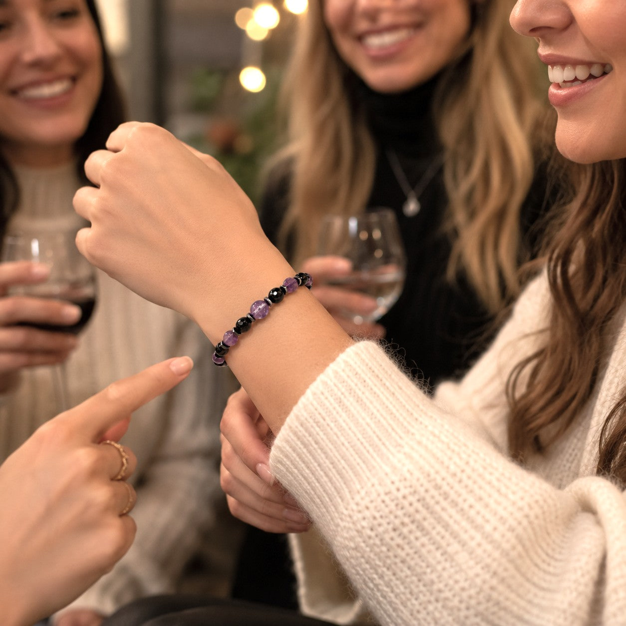 Personalized amethyst and black onyx bracelet on a woman's wrist, featuring genuine faceted purple amethyst gemstones, polished black onyx beads, and hematite spacers on an adjustable waterproof cord. This handmade crystal bracelet combines elegant purple and black gemstones for a timeless, minimalist look. This adjustable gemstone bracelet makes a thoughtful gift for women, birthday gift, anniversary gift, bridesmaid gift, friendship jewelry, healing crystal bracelet, or personalized everyday accessory.