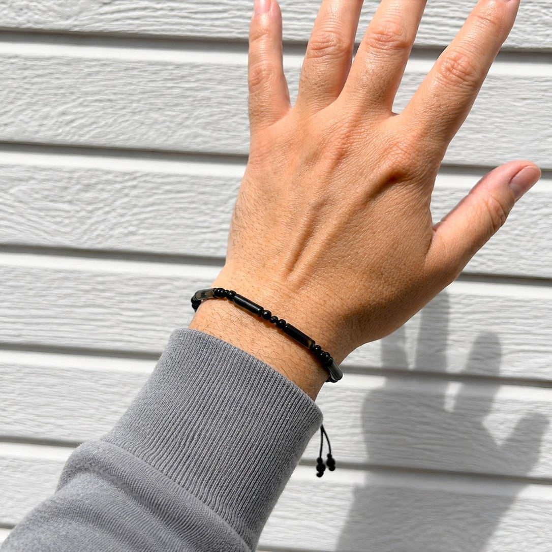 Black onyx tube bead bracelet worn on wrist showing adjustable fit, waterproof minimalist gemstone bracelet for men and women