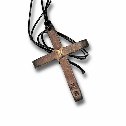 Small rustic brown leather cross custom personalized with initials wrapped in leather cord with a loop for hanging, made to display on a rear-view mirror.