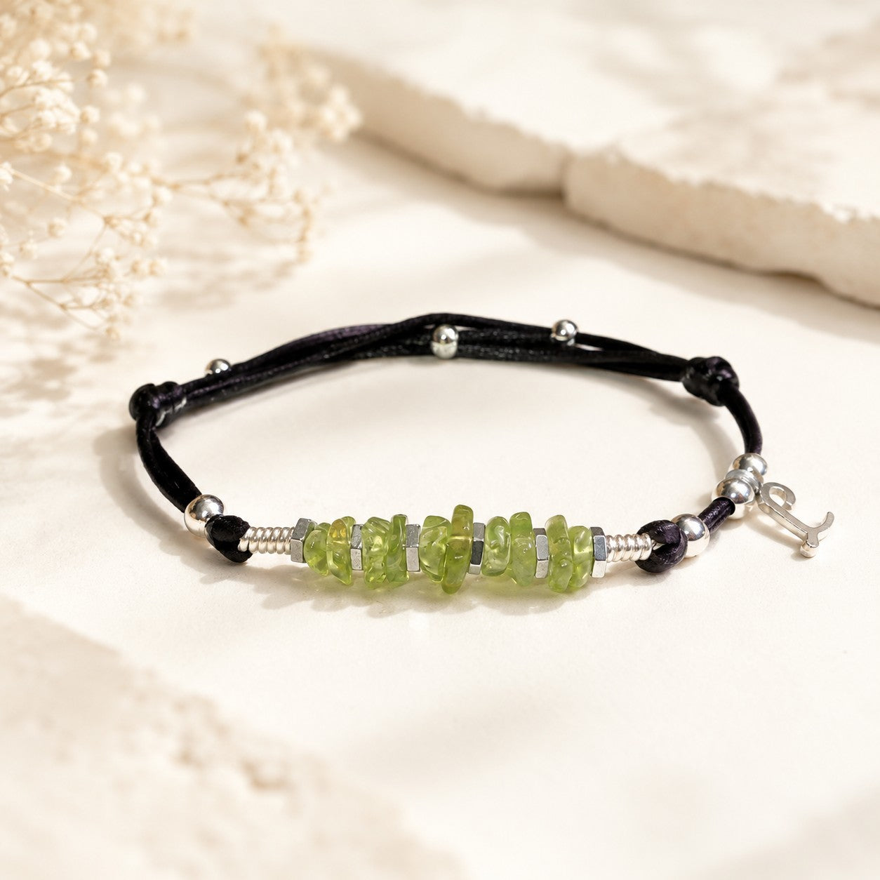 This stunning bracelet features Peridot chips and silver Hematite beads on a black nylon cord. The bracelet is waterproof and adjustable for a perfect fit. Durable and comfortable, this bracelet is ideal for everyday wear. Attract good luck!