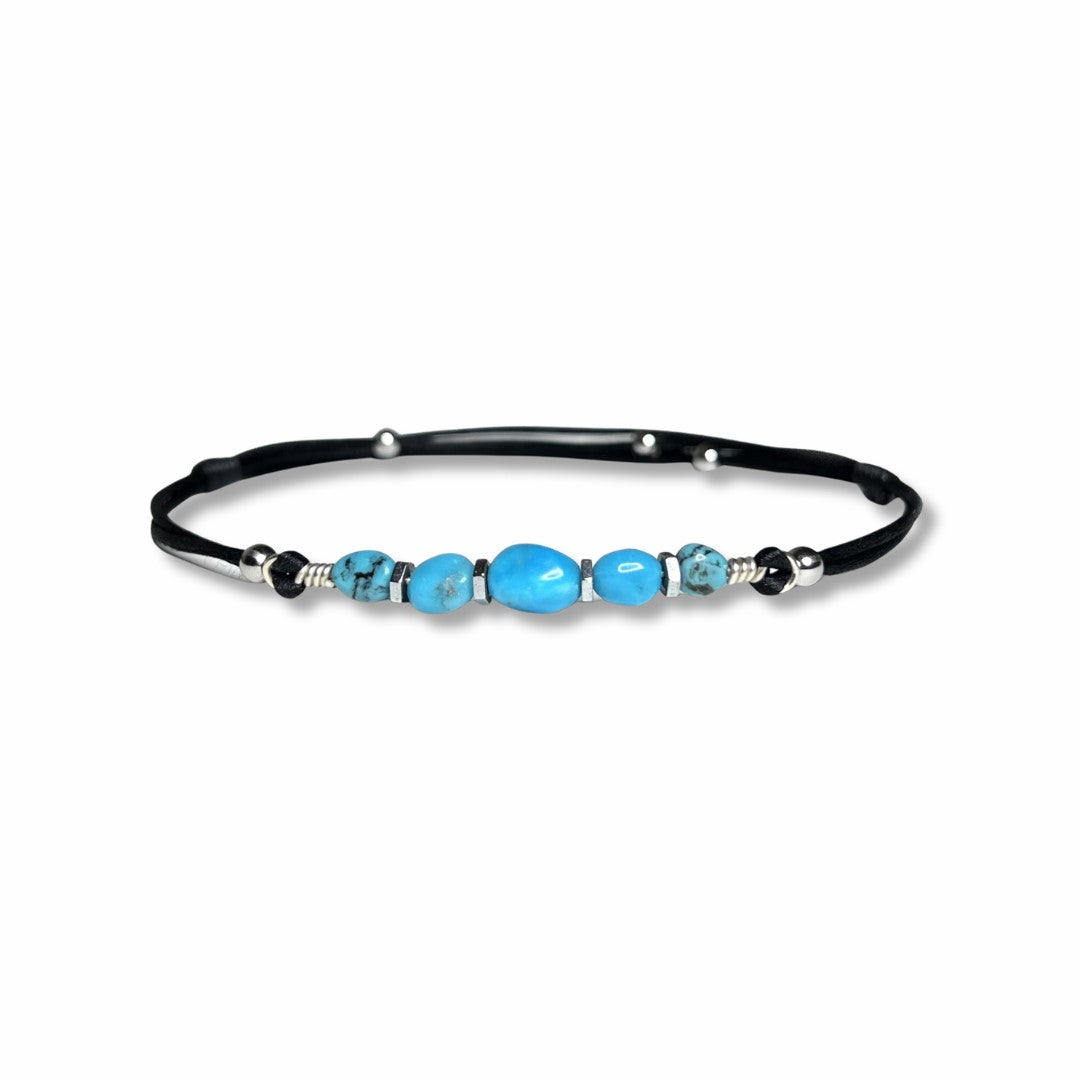 Adjustable and waterproof anklet. I use natural, untreated Turquoise nuggets and silver hematite beads on a black, silky nylon cord. A total of 5 gemstones,  in the center, a larger gemstone. Each stone is embellished with hematite beads around it.