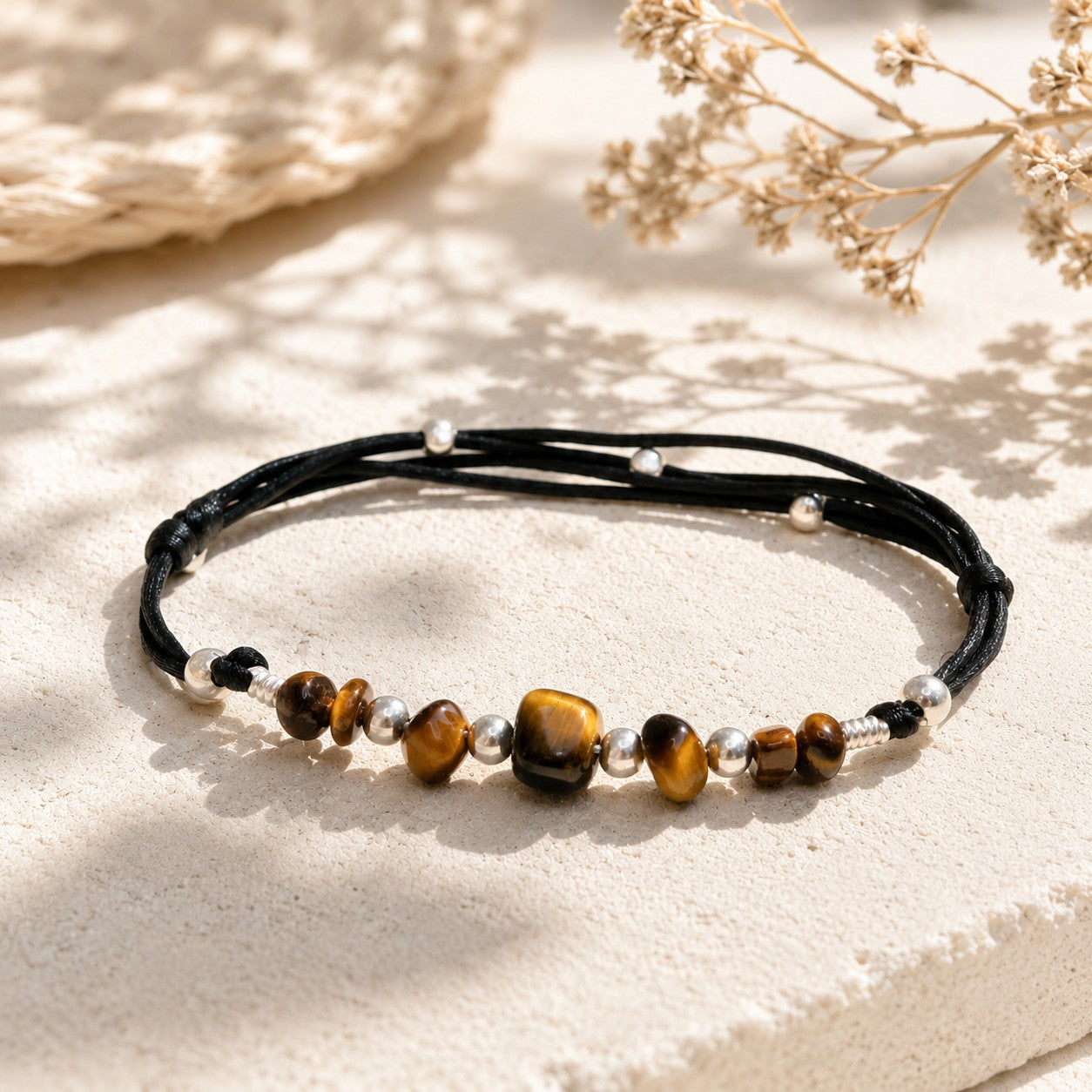 Handmade Tiger’s Eye anklet with polished brown-golden gemstone nuggets, accented by shiny silver beads on a black adjustable nylon cord. The anklet features a sliding knot clasp for a custom fit and an optional small initial charm. Presented gift-ready in a simple jewelry box.