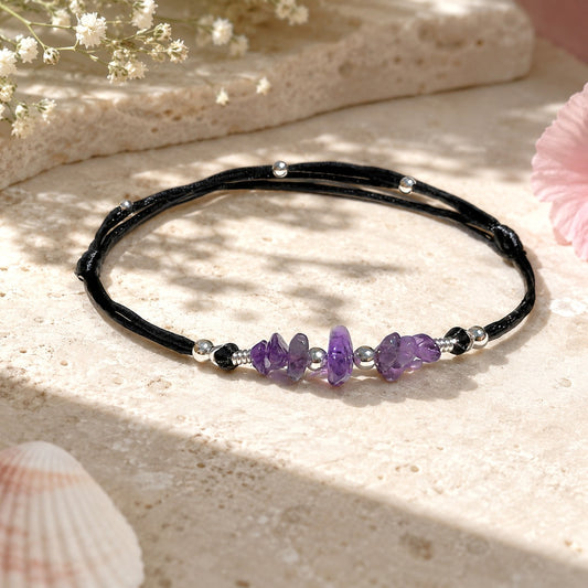 Dainty amethyst anklet with smooth purple gemstones on a black adjustable nylon cord, accented with silver-plated beads and an optional initial charm. A waterproof, personalized gift for women or teens, ideal for birthdays, holidays, or spiritual healing.