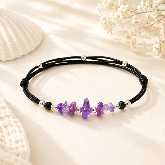 Dainty Amethyst bracelet with smooth purple gemstone nuggets on a black adjustable nylon cord, accented with silver-plated beads and one customizable initial charm. A waterproof, handmade gift for women or teens, perfect for everyday wear and special occasions.