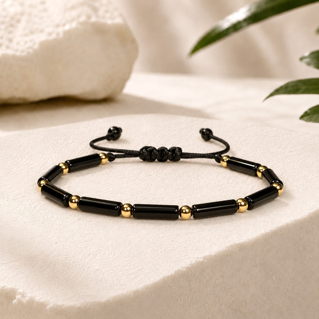 Adjustable and waterproof Black onyx beaded bracelet with gold accent beads  on a white background