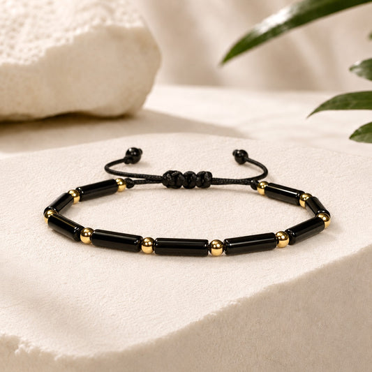 Adjustable and waterproof Black onyx beaded bracelet with gold accent beads  on a white background