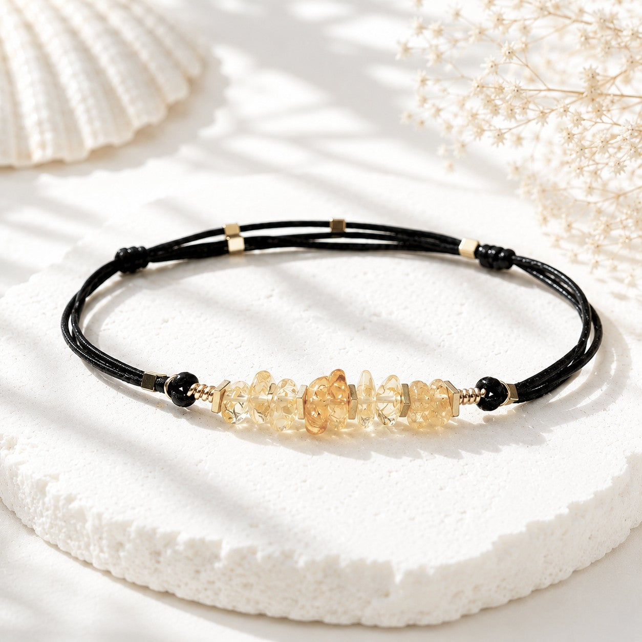 Handmade adjustable citrine anklet featuring natural golden-yellow citrine gemstone chips accented with gold hematite spacer beads on a double black leather cord. The bracelet is minimalist and elegant, symbolizing positivity, success, and good fortune. Displayed on a clean white background with soft shadows, the anklet’s warm tones and natural textures stand out beautifully.