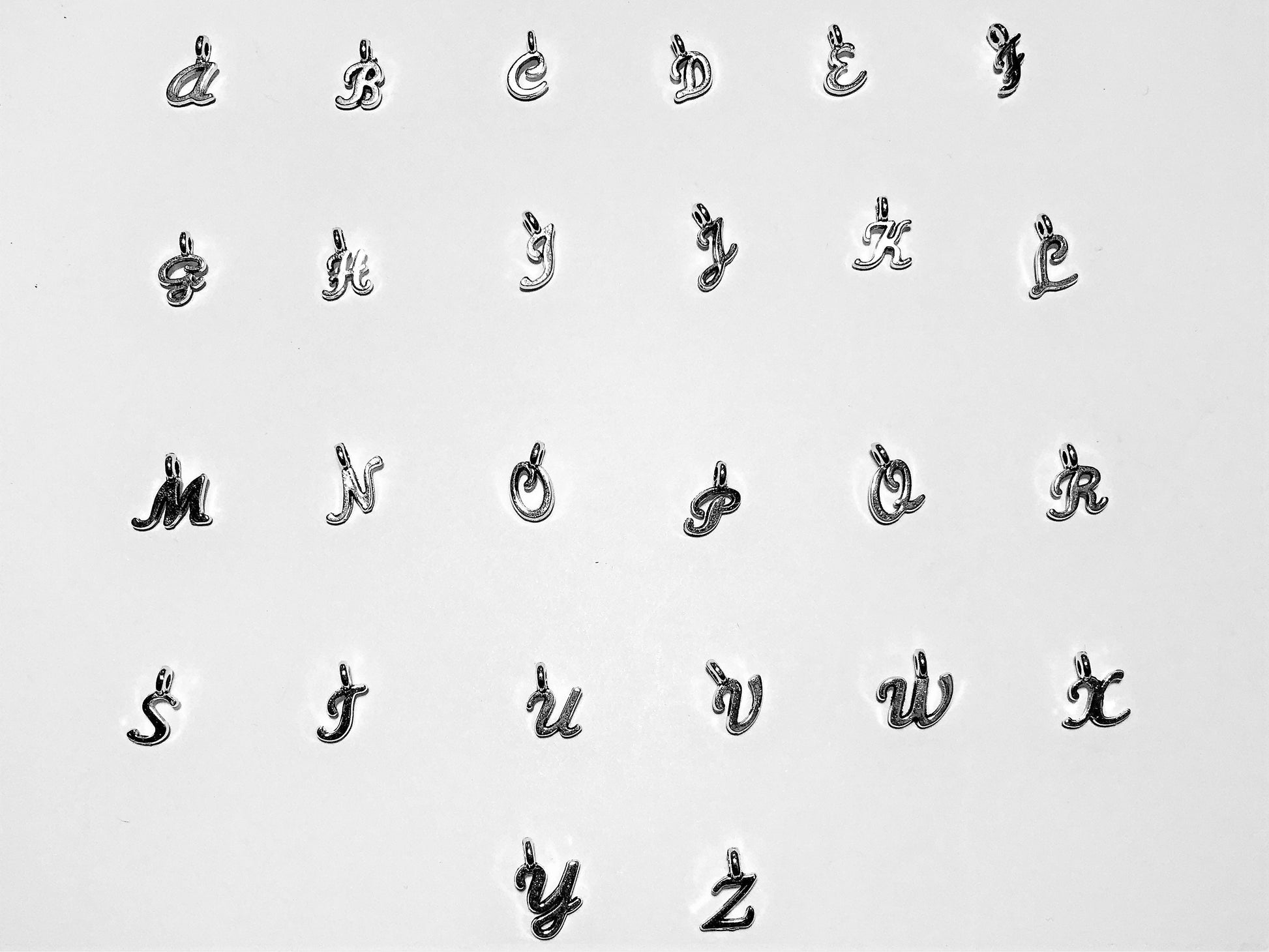 Silver tone Initial letter charms for personalization in alphabetical order.