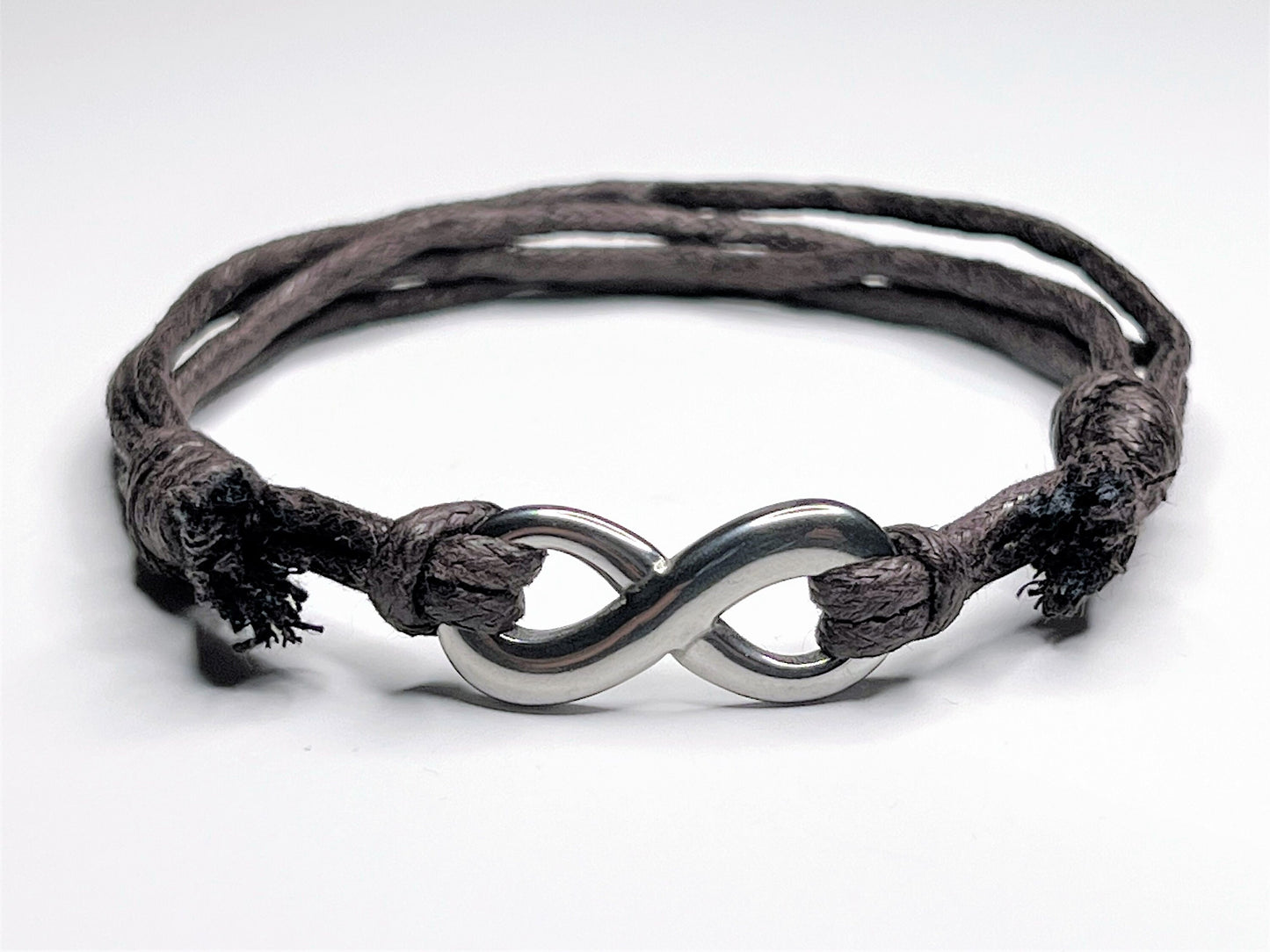 Infinity Charm Bracelet. Made with Brown Waxed Cotton cord and Stainless Steel Infinity Charm. Easily adjustable with a sliding knot. Waterproof.