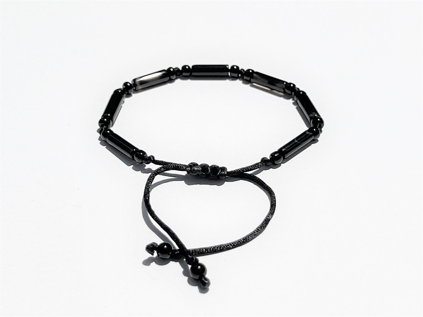 The back side of the bracelet shows an easily adjustable macramé sliding clasp. End of strings embellished with tiny round beads.