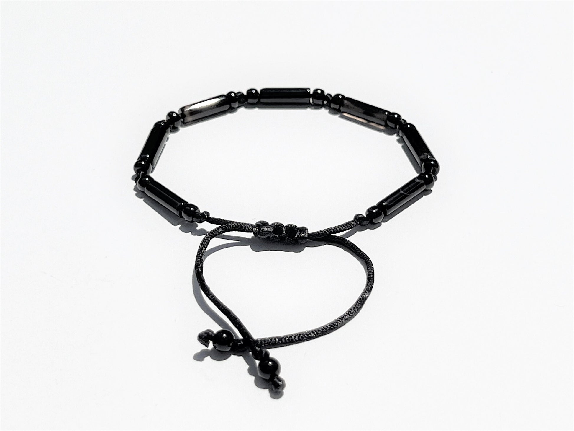 The back side of the bracelet shows an easily adjustable macramé sliding clasp. End of strings embellished with tiny round beads.