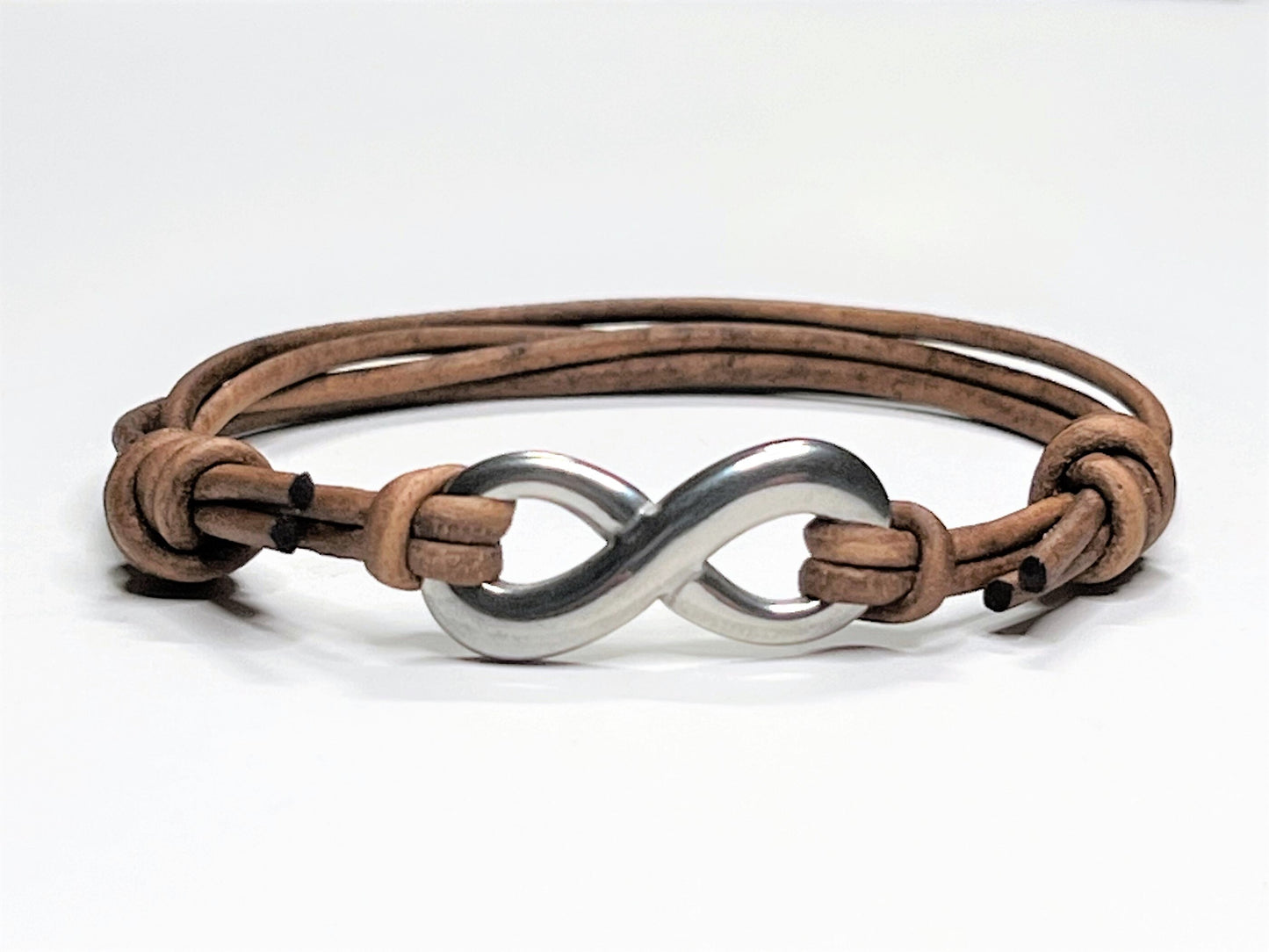 Distressed Tan Leather Cord Bracelet with Stainless Steal Infinity Charm. Bracelet is adjustable. Great gift for the 3rd Anniversary for Men and Women.