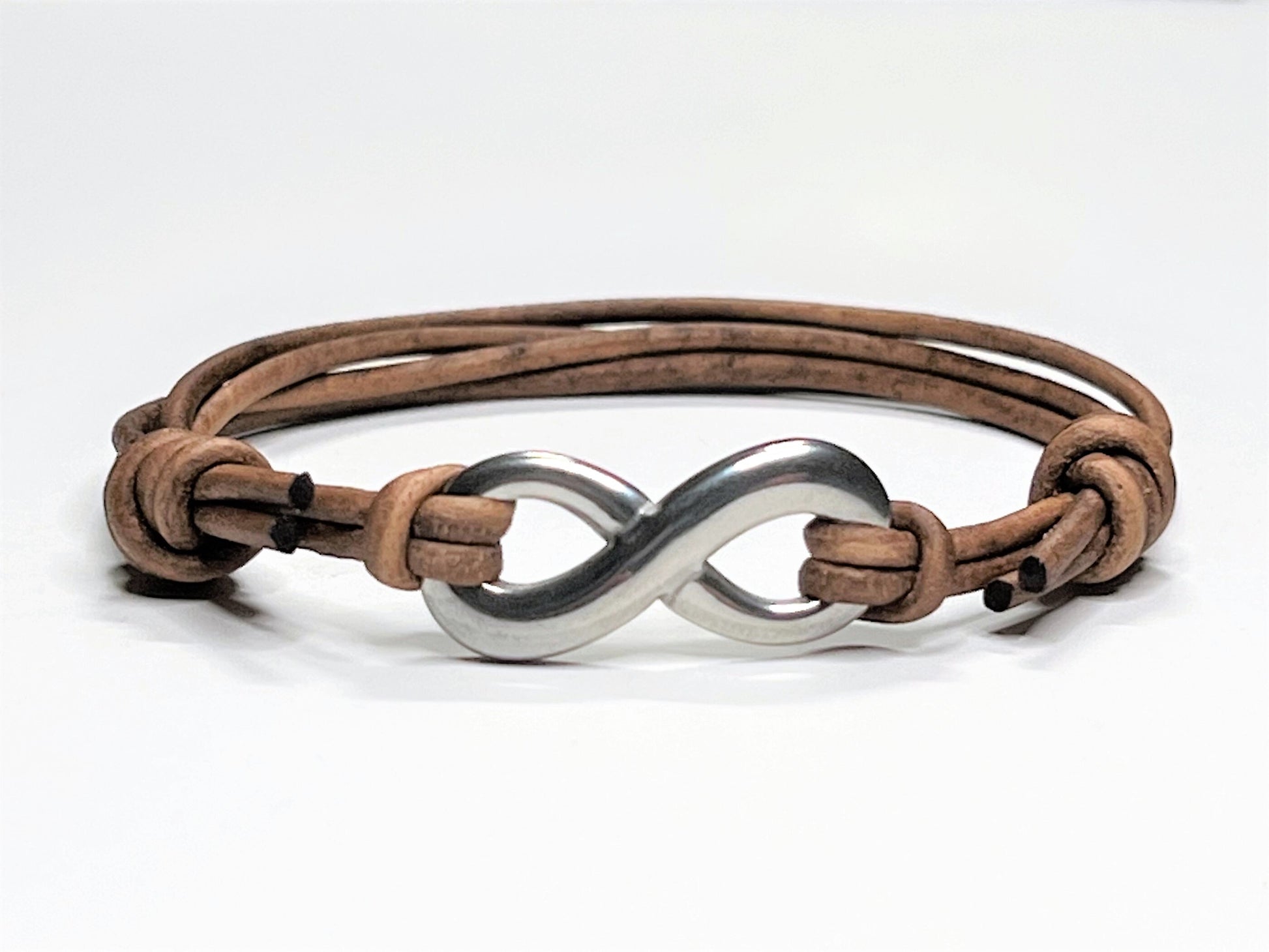 Distressed Tan Leather Cord Bracelet with Stainless Steal Infinity Charm. Bracelet is adjustable. Great gift for the 3rd Anniversary for Men and Women.