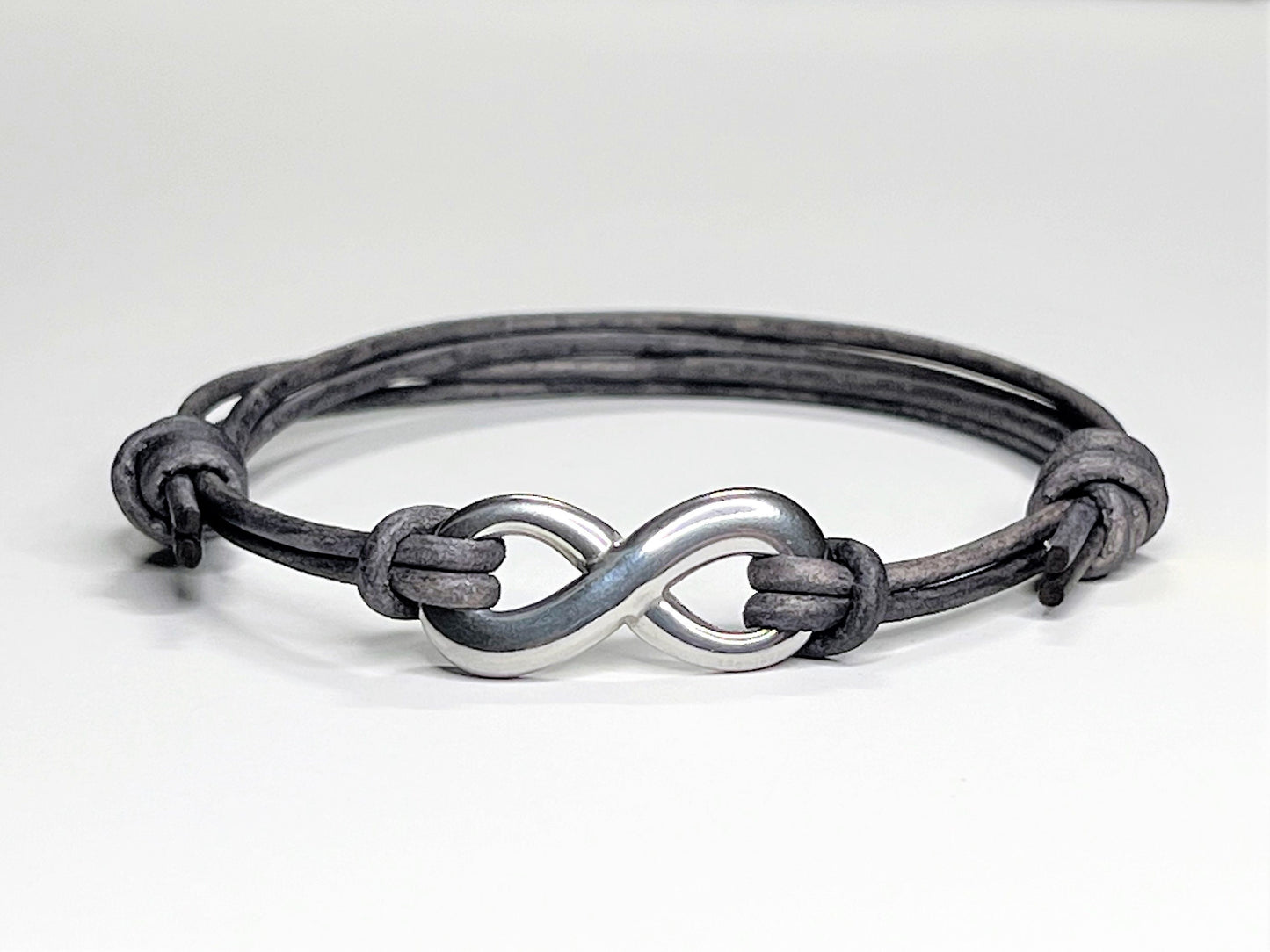 Distressed Grey Leather Cord Bracelet with Stainless Steal Infinity Charm. Bracelet is adjustable. Great gift for the 3rd Anniversary for Men and Women.