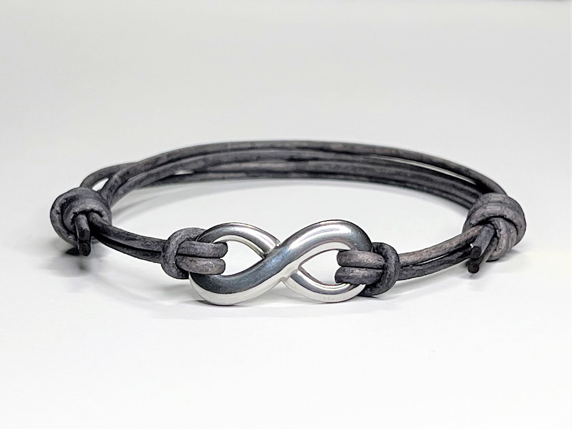 Distressed Grey Leather Cord Bracelet with Stainless Steal Infinity Charm. Bracelet is adjustable. Great gift for the 3rd Anniversary for Men and Women.