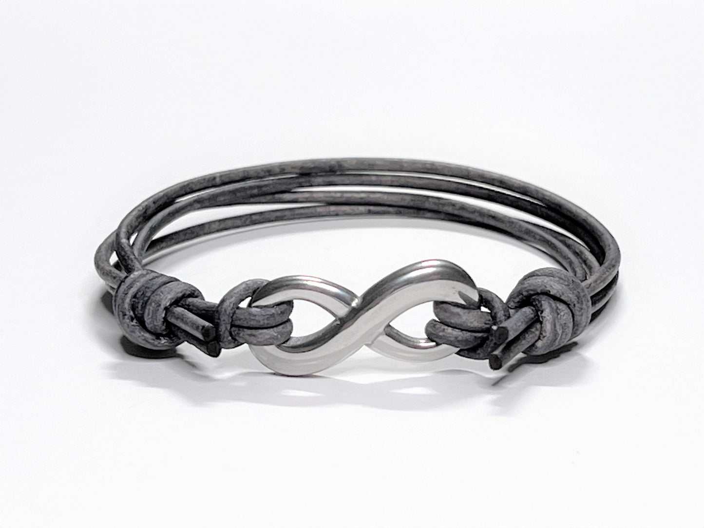 Distressed Grey Leather Cord Bracelet with Stainless Steal Infinity Charm. Bracelet is adjustable. Great gift for the 3rd Anniversary for Men and Women. Bracelet adjusted to its smaller setting.