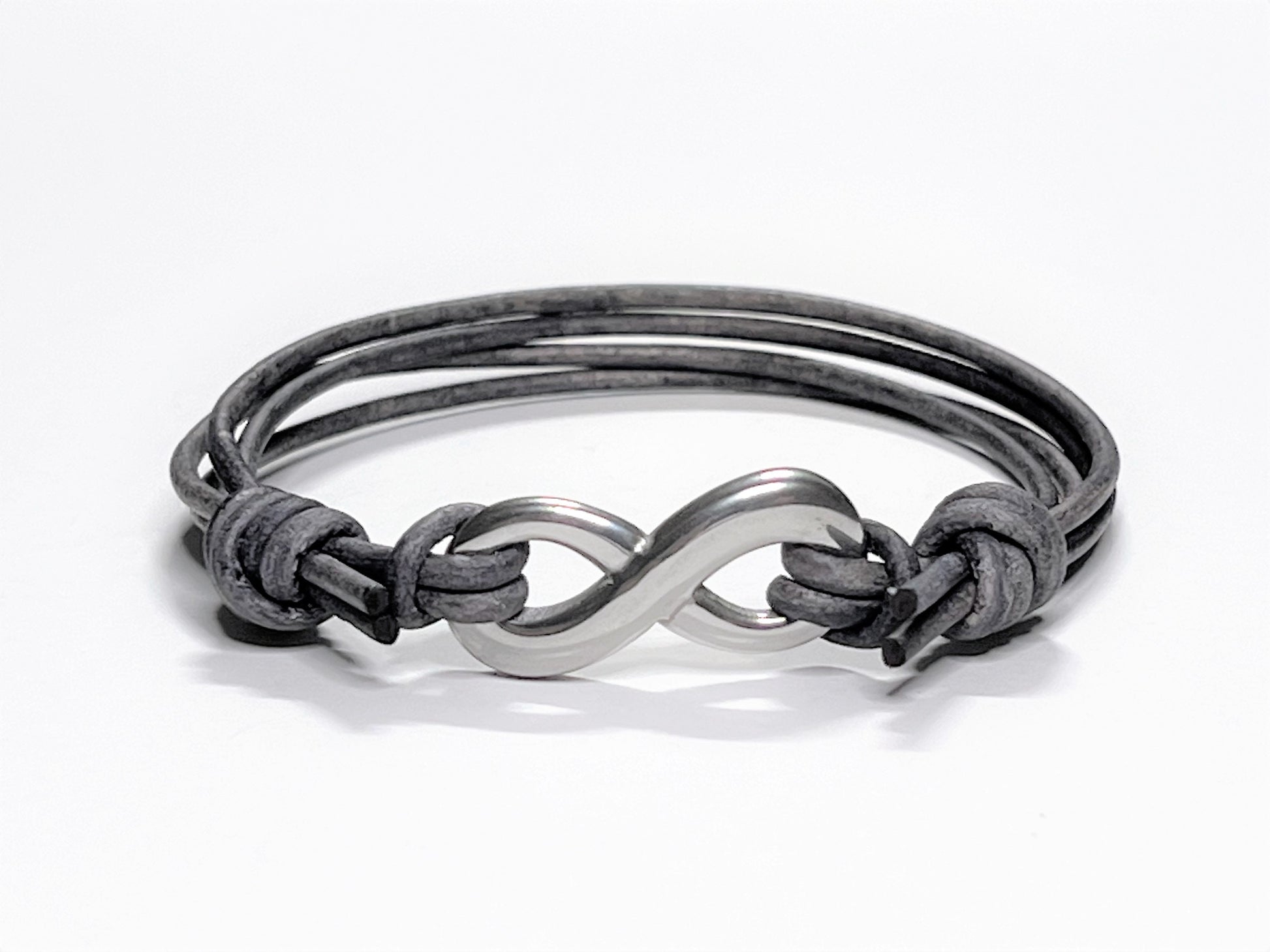 Distressed Grey Leather Cord Bracelet with Stainless Steal Infinity Charm. Bracelet is adjustable. Great gift for the 3rd Anniversary for Men and Women. Bracelet adjusted to its smaller setting.