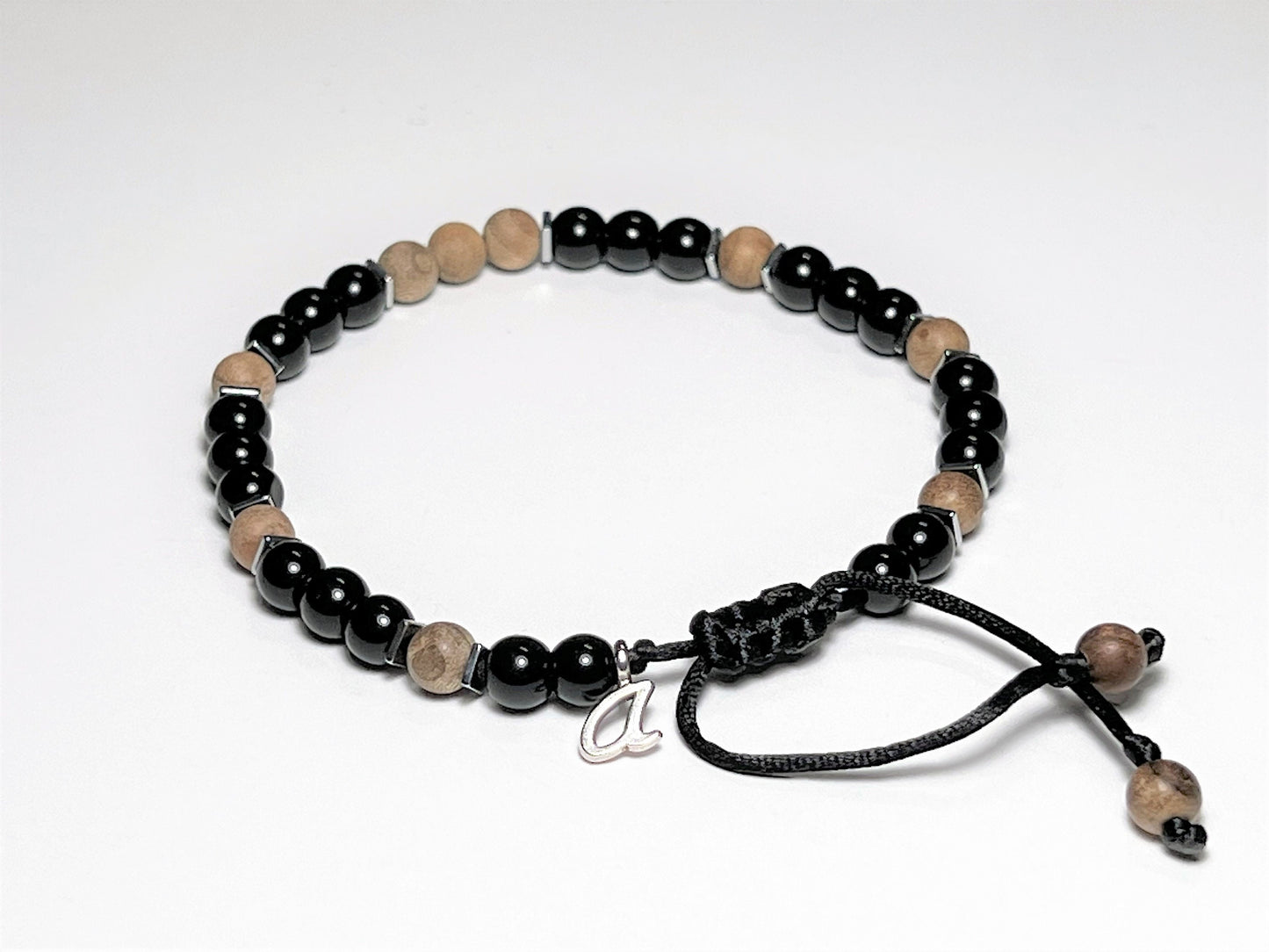 Sandalwood bracelet personalized with one silver color initial letter charm. The letter was added to the bracelet next to the clasp.
