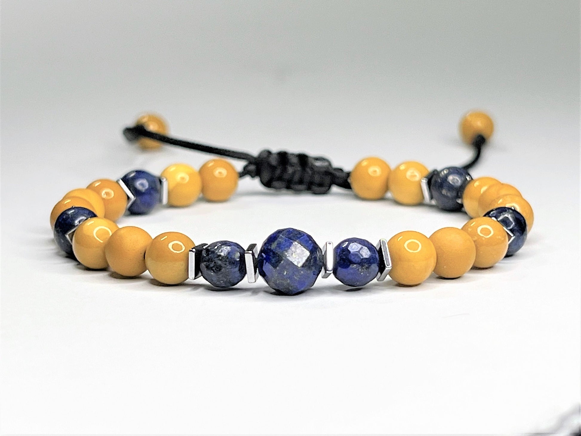 Mustard Yellow Makatite and Gorgeous  Navy Blue Lapis Lazuli bracelet. The bracelet can be easily adjusted by pulling strings. In the middle of the bracelet is a larger Lapis stone to bring more attention to the natural beauty.
