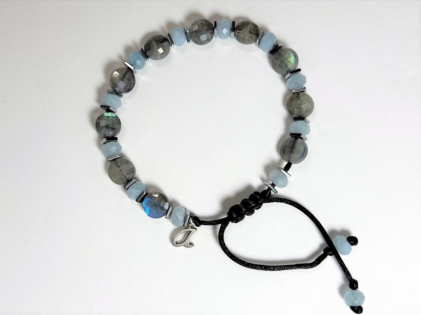 Bracelet is personalized with one initial silver-colored charm. Initial placed next to the sliding clasp.