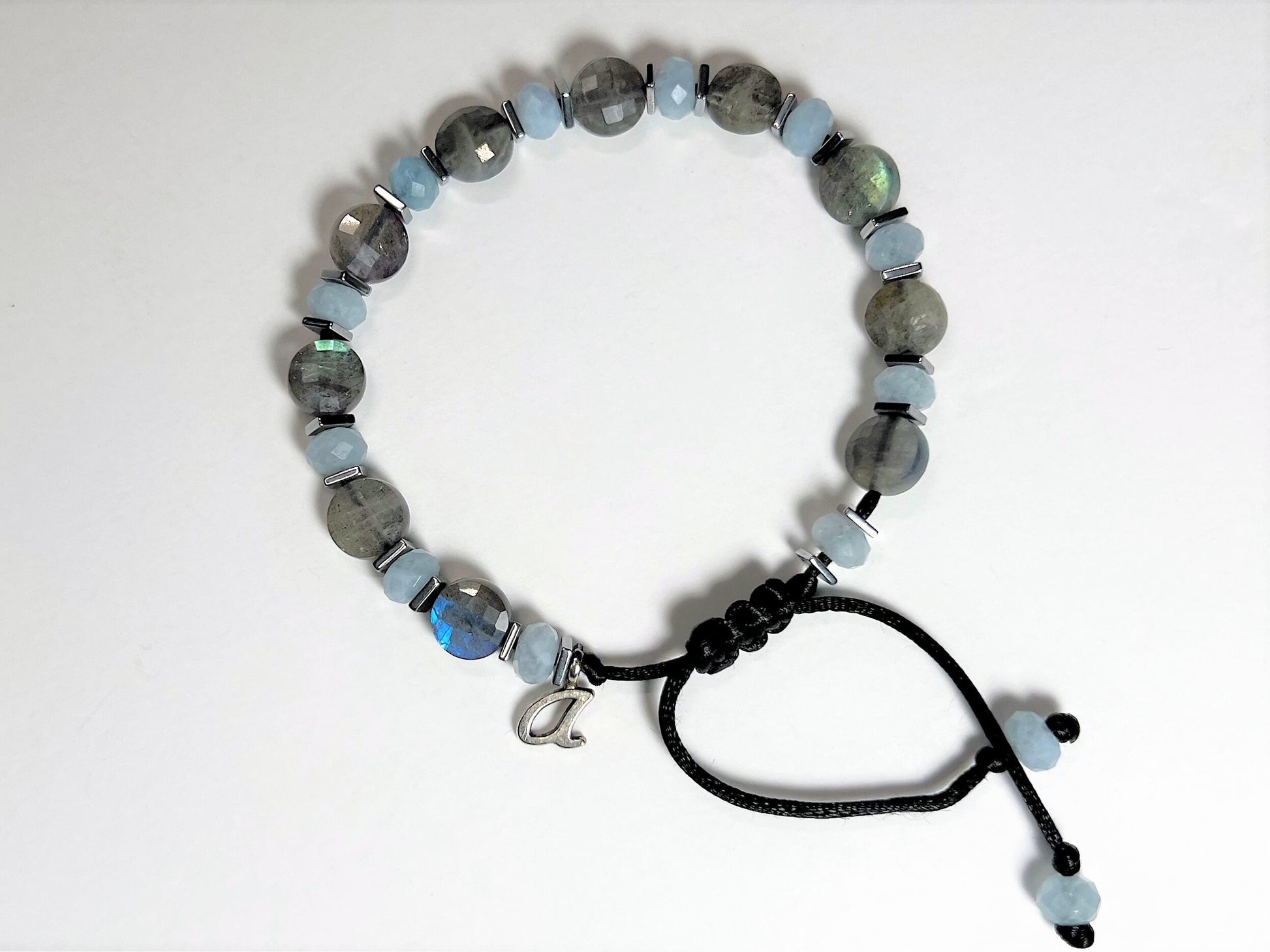 Bracelet is personalized with one initial silver-colored charm. Initial placed next to the sliding clasp.