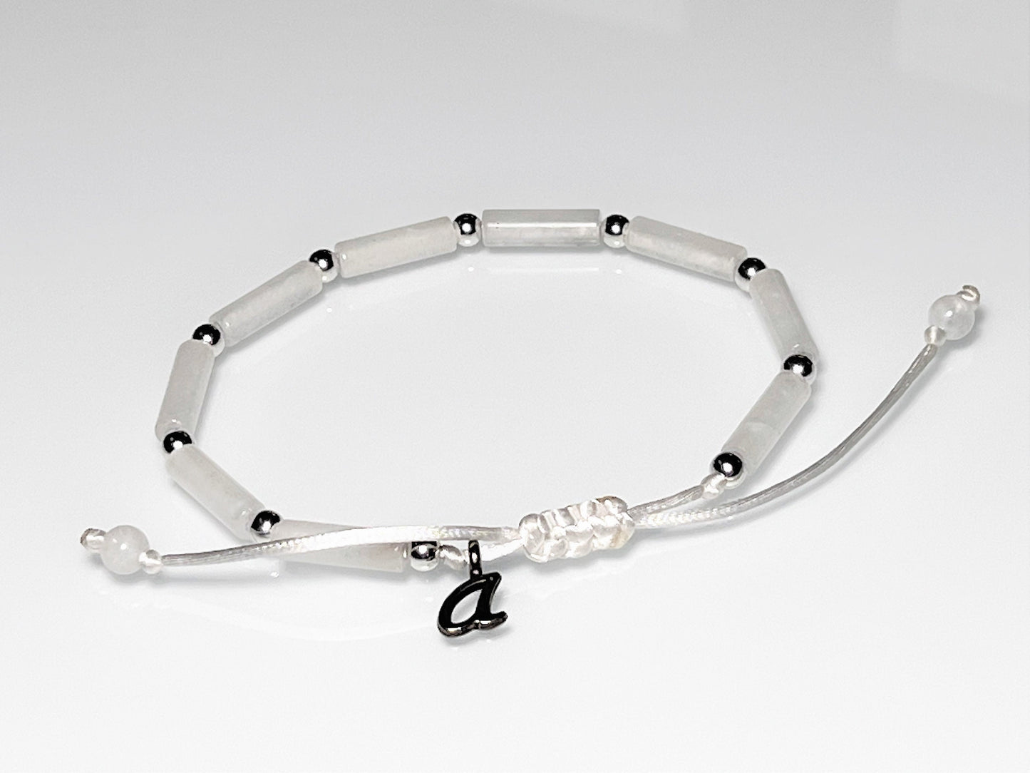 Initial personalized White jade tube bead bracelet with silver accents on an adjustable white cord.