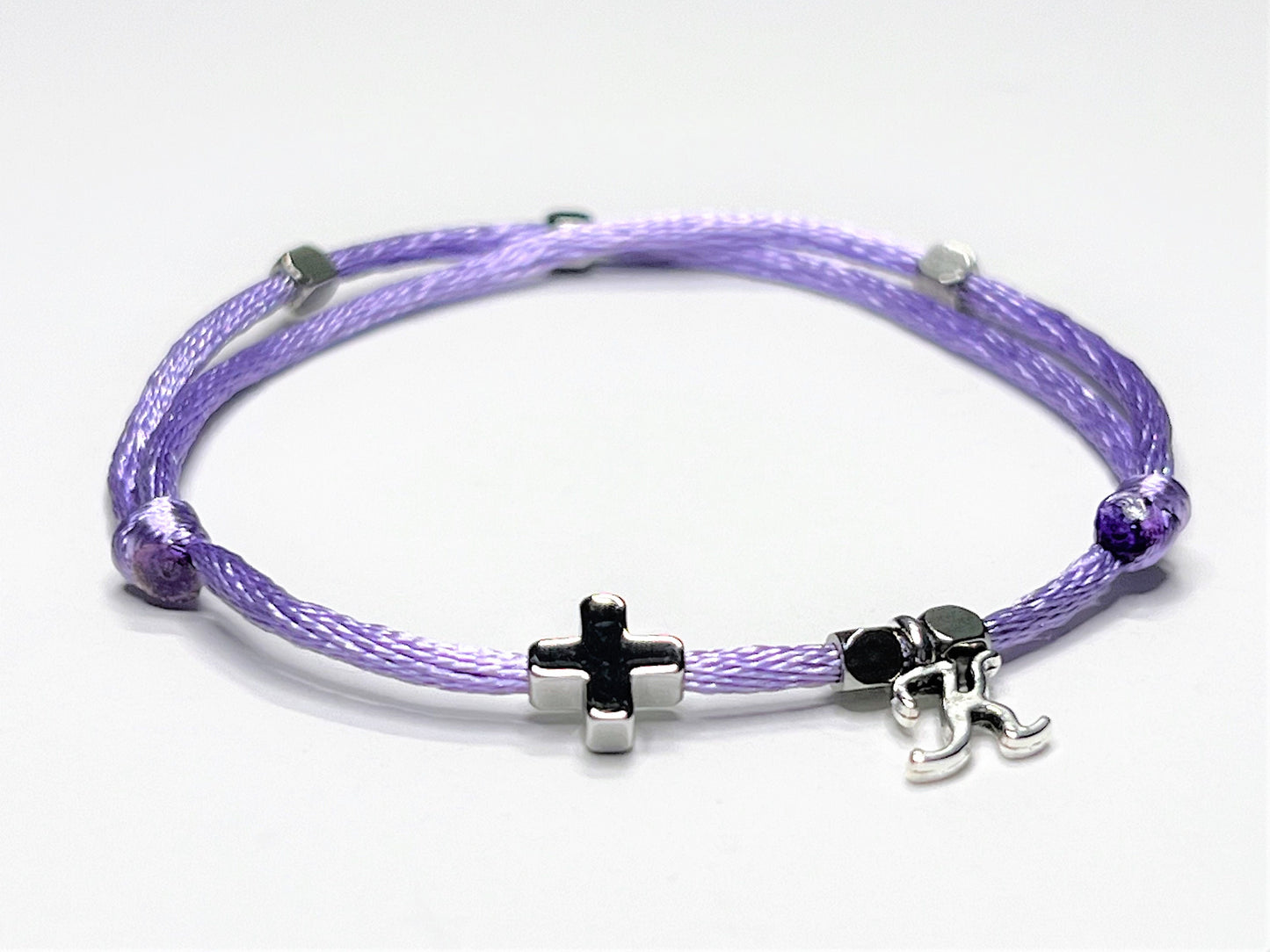 Purple nylon string bracelet with a white gold cross personalized with a single initial charm.