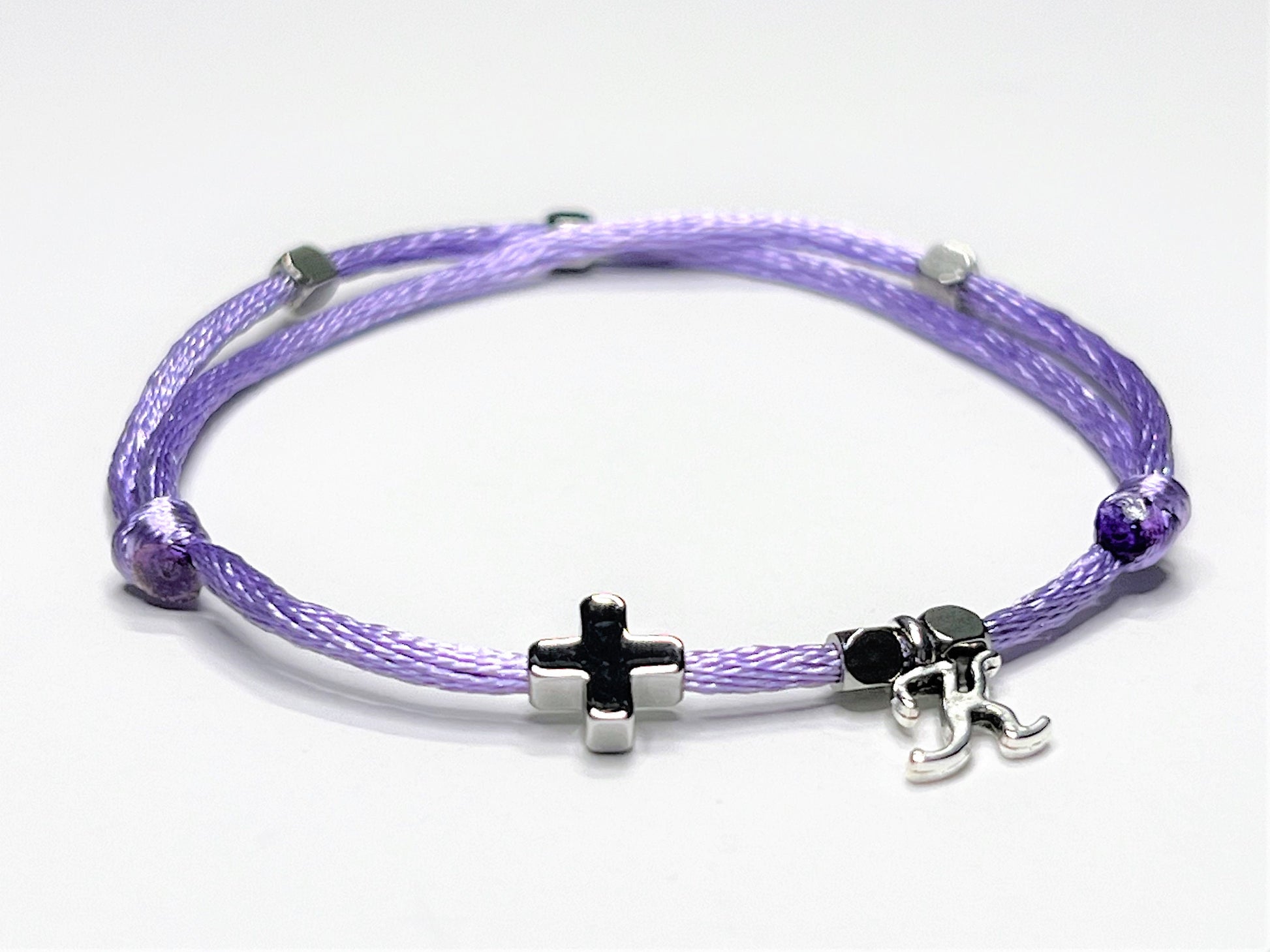 Purple nylon string bracelet with a white gold cross personalized with a single initial charm.