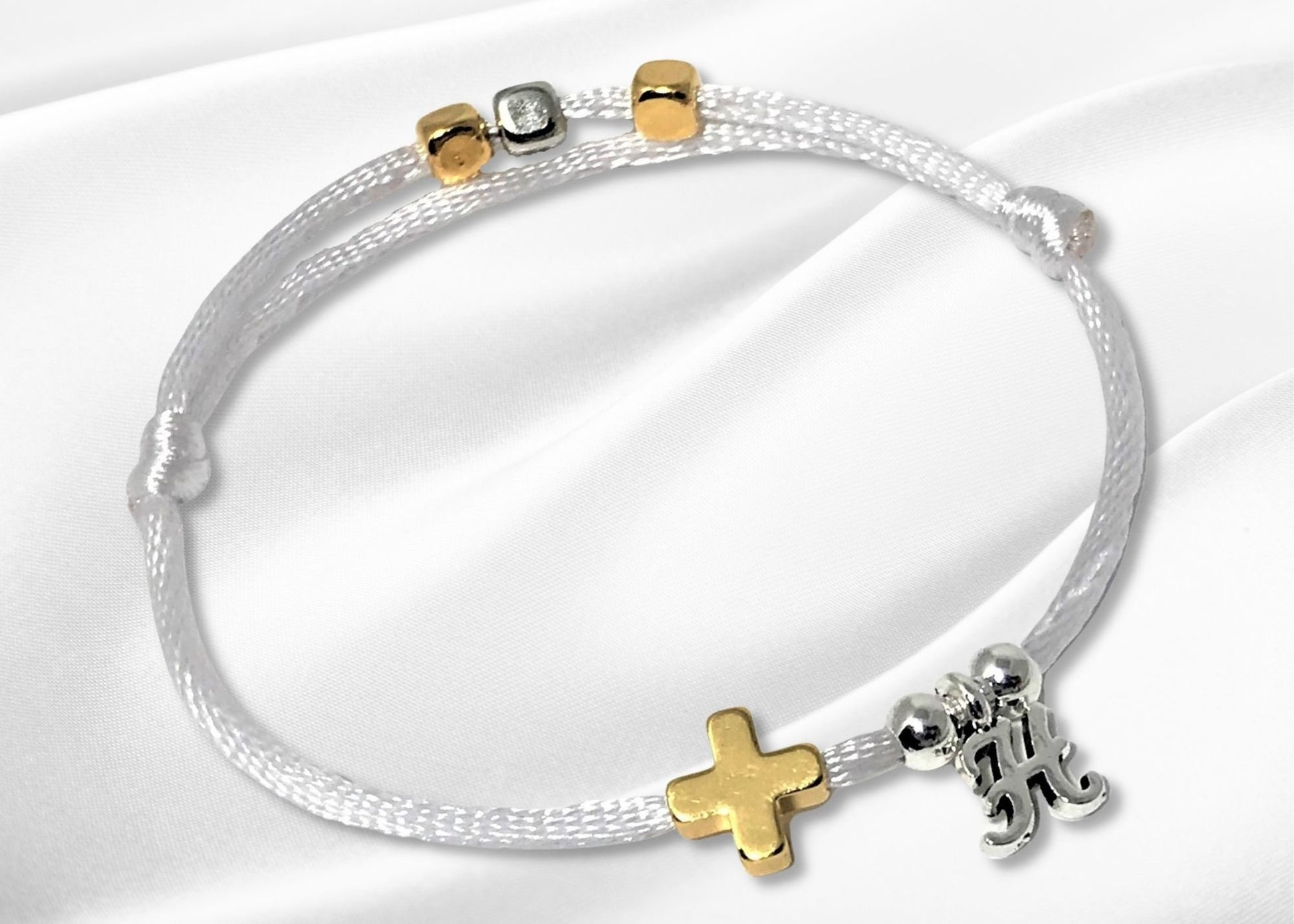 White nylon string bracelet with a gold cross personalized with a single initial charm.