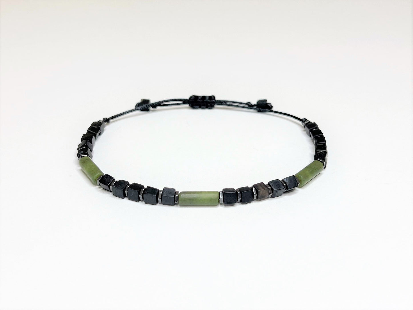 Extended opening of a green jade and onyx adjustable bracelet