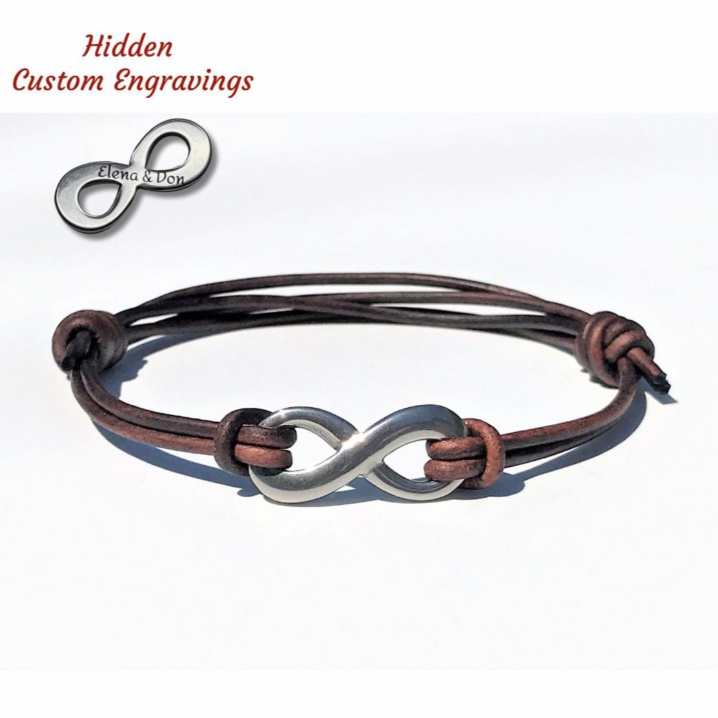 The leather bracelet features a smooth cord and a stainless steel infinity charm. It adjusts easily with a sliding knot to fit various wrist sizes. Engraving on the charm's back allows for personalization, making it an ideal, comfortable gift.