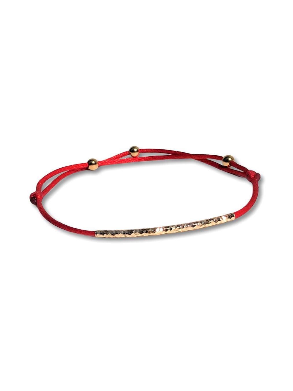 Handcrafted Adjustable Tiny Red String Bracelet for Good Luck. It features a silky red string complemented by a faceted gold tube and 3 delicate beads. Personalize it with 1 initial charm—a perfect blend of elegance and meaning.
