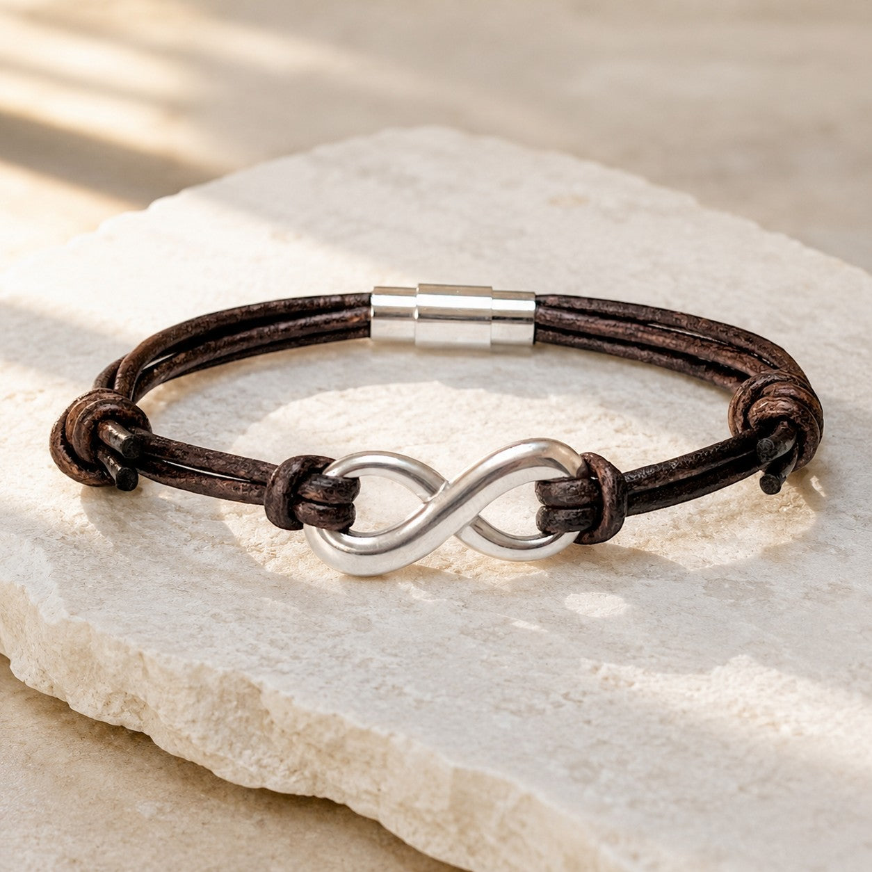 Distressed Brown Multi-String Leather Bracelet featuring an infinity stainless steel charm framed by two knots on each side, secured with a magnetic clasp. A timeless unisex design, perfect as a leather anniversary gift for both men and women.