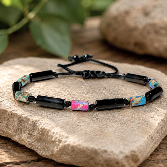 Rainbow Imperial Sea Sediment Jasper and Black Onyx adjustable bracelet featuring vibrant pink, turquoise, cream, and earthy-toned jasper beads paired with polished black onyx tube beads. Handcrafted on a durable waterproof cord with an adjustable sliding knot closure for a comfortable fit. This unisex gemstone bracelet combines natural stone beauty with a modern minimalist design, making it perfect for everyday wear, stacking, beach vacations, spiritual jewelry collections, and meaningful gifts. 