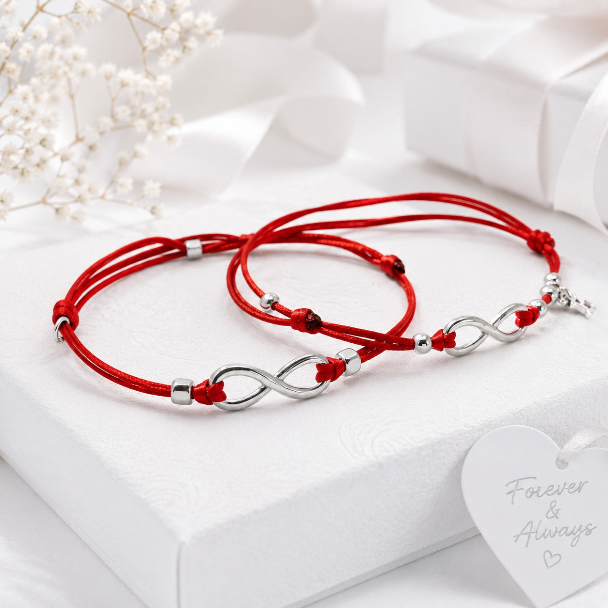 Matching personalized red string infinity bracelets with adjustable waterproof nylon cord and polished stainless steel infinity charms. Handmade couple bracelets featuring customizable initial charms, perfect as matching his and hers bracelets, anniversary gifts, Valentine's Day gifts, wedding gifts, long-distance relationship bracelets, and everyday minimalist jewelry.
