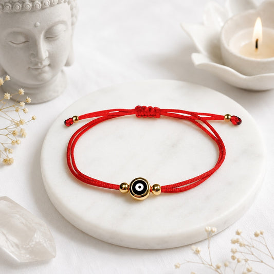 Adjustable red string anklet featuring a protective blue evil eye charm and a round gold-plated initial letter charm. The anklet is handmade with silky nylon cord, knotted for adjustability, and accented with 18K gold-filled beads. It is designed for everyday wear, waterproof, and symbolizes good luck and protection. Ideal as a personalized gift for best friends, daughters, or couples.